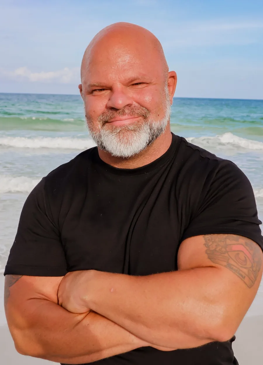 Coach Jim Laird smiling on the beach